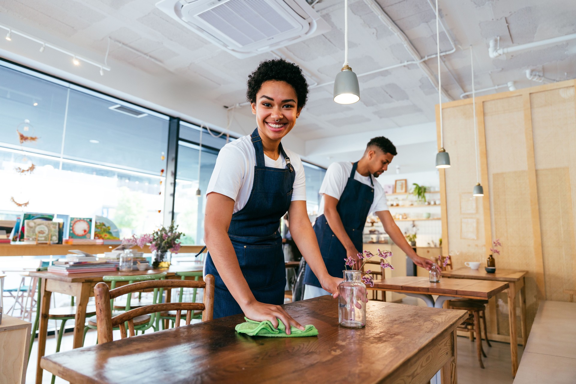 Barista and waiter working in a bar cafeteria shop